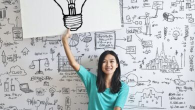 woman draw a light bulb in white board