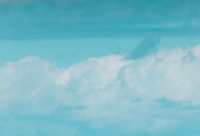 turquoise blue sky with white swirling clouds